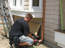 securing each downspout with wall brackets